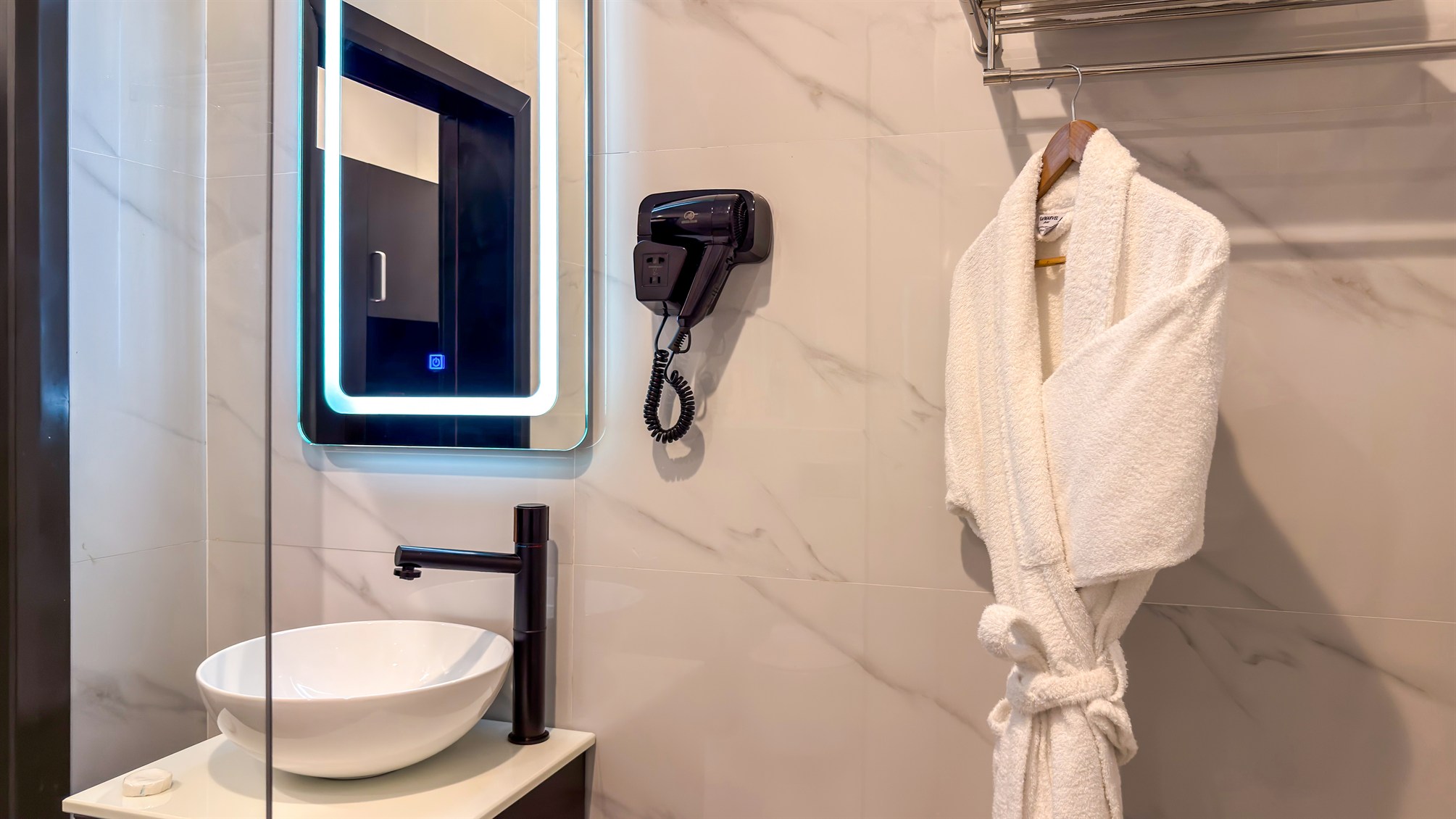 A bathrobe and washbasin in a marble bathroom
